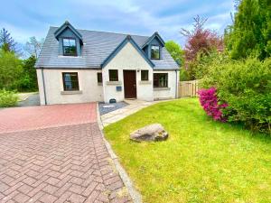 a house with a brick driveway in front of a yard at Lochindaal - Beautiful, Spacious 4 Bedroom House in Kintyre in Whitehouse