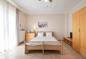 Un dormitorio con una cama y un televisor en una habitación. en Alex & Billy House by Travel Pro Services - Nea Flogita Halkidiki, en Zográfos