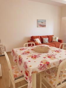 uma mesa de jantar com uma toalha de mesa florida em Appartamento Corallo Rosso e Stella Blu em Belvedere Marittimo