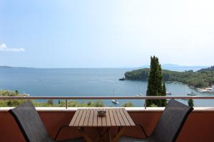 a balcony with a wooden table and two chairs at Villa Natalia in Kalami