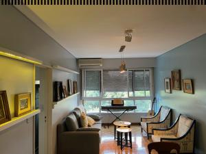 een woonkamer met een bank, stoelen en een tafel bij Stylish 3 BR Family Apt in Palermo in Buenos Aires