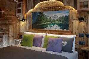 a bedroom with a bed with a painting on the wall at Chalet Matterhorn Francois with SPA and Breakfast - 100mt lift in Breuil-Cervinia