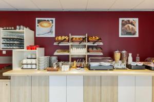 - une cuisine avec un comptoir avec de la nourriture dans l'établissement ACE Hôtel Thionville - Porte du Luxembourg, à Thionville