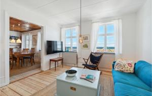 グドイェムにあるBeautiful Home In Gudhjem With 3 Bedrooms And Wifiのリビングルーム(青いソファ、テーブル付)