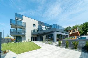 加茨比亚格拉Apartamenty i Pokoje Złote Piaski的一座前面有草坪的大楼