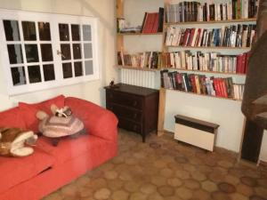 - un salon avec un canapé rouge et une étagère à livres dans l'établissement Maison Toulon ouest, à Toulon
