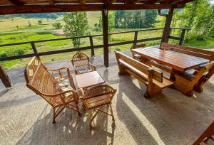 a picnic table and chairs on a porch with a table and bench at Plitvice RH Hostel Rooms in Jezerce
