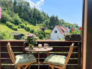 een tafel en stoelen op een balkon met uitzicht op een huis bij Ferienwohnung Baumkrone in Waldeck