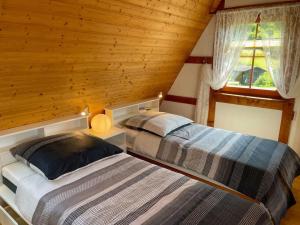 twee bedden in een kamer met houten wanden bij Ferienwohnung Baumkrone in Waldeck