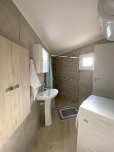 a small bathroom with a sink and a refrigerator at Asterion Bella View in Zaros