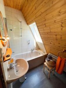 een badkamer met een wastafel en een bad bij Ferienwohnung Baumkrone in Waldeck