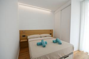 una camera da letto con un letto e due pantofole blu sopra di Suites Port Cambrils a Cambrils