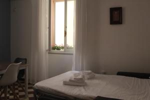 una camera da letto con un letto e una finestra con asciugamani di Suite al castello a Sassari