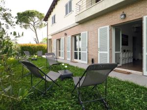 un groupe de chaises assises dans l'herbe près d'une maison dans l'établissement Rosa Bianca - 5 minuti dal Centro con Giardino e Parcheggio Privato, à Pérouse