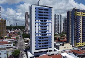 un edificio alto azul y blanco en una ciudad en Ap Manaíra, prático e acolhedor, en João Pessoa