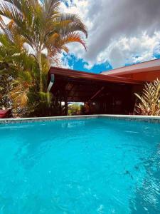 a large blue swimming pool in front of a house at Casa Vacacional Nieves en PZ-Piscina Privada-WIFI in San José