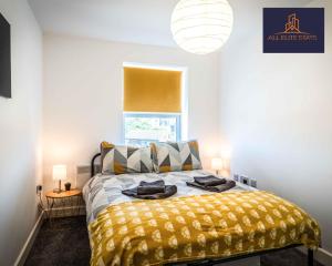 a bedroom with a bed with a yellow blanket at Swan House Apartment 7 - 2 Bed Apartment - Sleeps 5 - Free Parking - Liverpool - close to city centre - By ALL ELITE STAYS in Liverpool