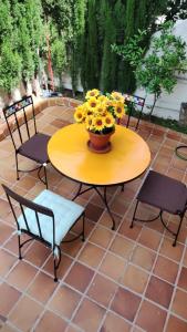 une table et des chaises jaunes avec un vase de fleurs dans l'établissement Bungalow PLAYA POBLA DE FARNALS, à Las Canteras