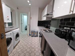 een keuken met een wasmachine en een wasmachine bij Cyfarthfa House in Cardiff