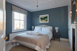 a blue bedroom with a bed with towels on it at Cosy retreat, perfectly located just a min walk from Deal Beach and Castle in Deal
