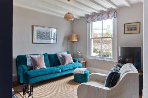 a living room with a blue couch and a tv at Cosy retreat, perfectly located just a min walk from Deal Beach and Castle in Deal