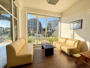 a living room with couches and a large window at Mint Family Hotel in Ravda