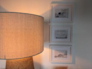 a room with a lamp and pictures on the wall at Casas do Horizonte in Ribeiras