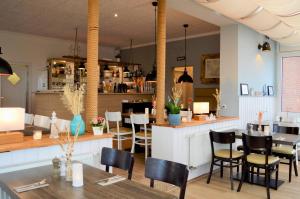 un restaurant avec une table et des chaises ainsi qu'un bar dans l'établissement Bootsmann 05, à Schashagen