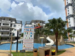 a pool with a water slide in front of some buildings at 2-bedroom @ Swiss Garden Resort Residences in Kuantan