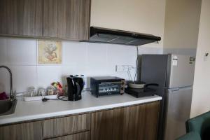 a kitchen counter with a microwave and a refrigerator at 2-bedroom @ Swiss Garden Resort Residences in Kuantan