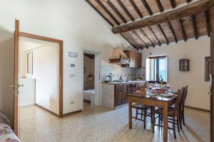 uma cozinha e sala de jantar com mesa e cadeiras em Villa Montepescini em Murlo