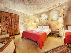 um quarto com uma cama num quarto de pedra em Asma Altı Cave Suit's em Nar