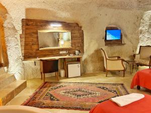 a living room with a table and chairs and a rug at Asma Altı Cave Suit's in Nar