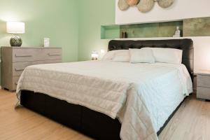 a bedroom with a large bed and a dresser at HABITAT- Apartments&Rooms in Cerignola