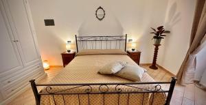 um quarto com uma cama com duas almofadas e um relógio na parede em La Cattedrale Rooms em Assis
