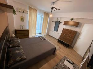 a bedroom with a bed and a dresser in it at Seawave Beach Apartament in Constanţa