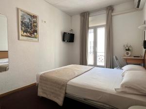 Habitación de hotel con cama y ventana en Little Palace en Cannes