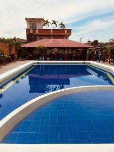 a blue swimming pool with a house in the background at Leño Verde in Espinal