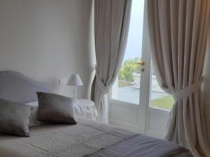 um quarto com uma cama e uma grande janela em VILLA AGA em Noli