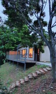 a home with a large porch and a tree at Xianyan Villa B&B in Sanyi