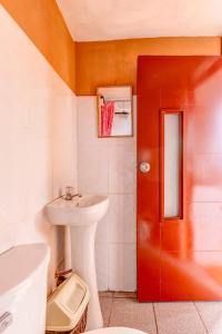 a bathroom with a sink and a red door at Kely3 Cuarto Piso in Lima