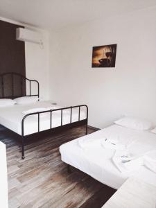 2 Betten in einem Zimmer mit weißen Wänden und Holzböden in der Unterkunft Casa Marronne in Costinești