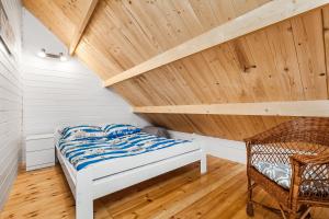 um quarto com uma cama e um tecto de madeira em Słoneczna Zatoka em Sławoszynko