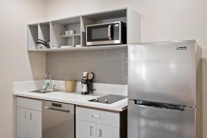 a kitchen with a stainless steel refrigerator and a microwave at The English Inn of Charlottesville in Charlottesville