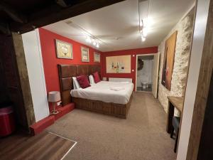 a bedroom with a bed and a red wall at The George Centre in Matlock