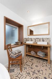 a bathroom with two sinks and a chair and a mirror at La Chaume des Xettes / 10-14 pers SPA - Vue Lac in Gérardmer