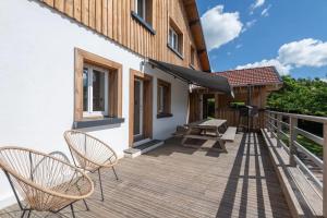 a wooden deck with chairs and a picnic table at La Chaume des Xettes / 10-14 pers SPA - Vue Lac in Gérardmer