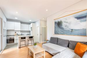ein Wohnzimmer mit einem Sofa und einer Küche in der Unterkunft Beautiful House in Matosinhos Beach - by Guest SPA in Matosinhos