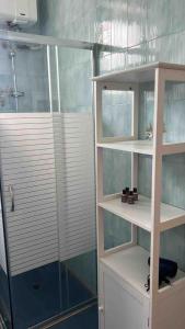 baño con estantes blancos y ducha en Villa Mariangela, en Latiano