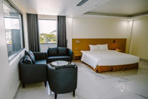 pokój hotelowy z łóżkiem i 2 krzesłami w obiekcie SUNRISE Hotel HA TIEN w mieście Hà Tiên